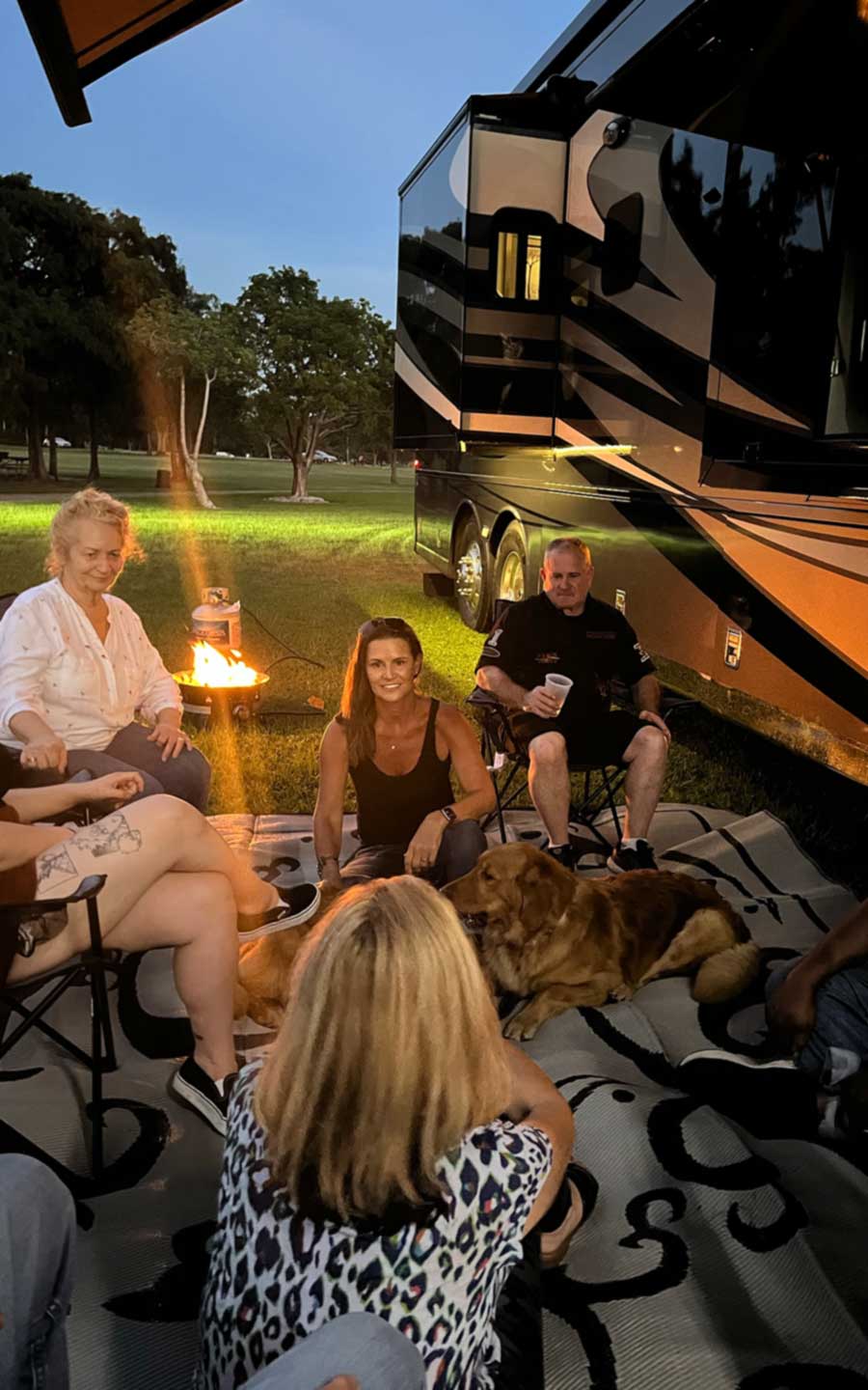 Friends relaxing outside of their RV at night