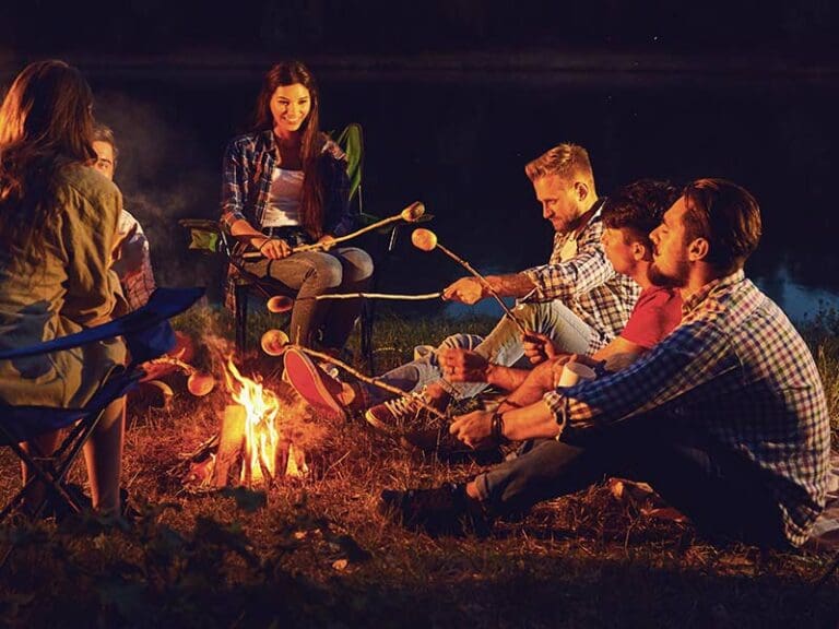 Friends roasting marshmallows by a campfire