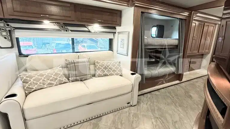 RV Rental: 41' Winnebago Forza - Interior with couch, bunk beds and credenza